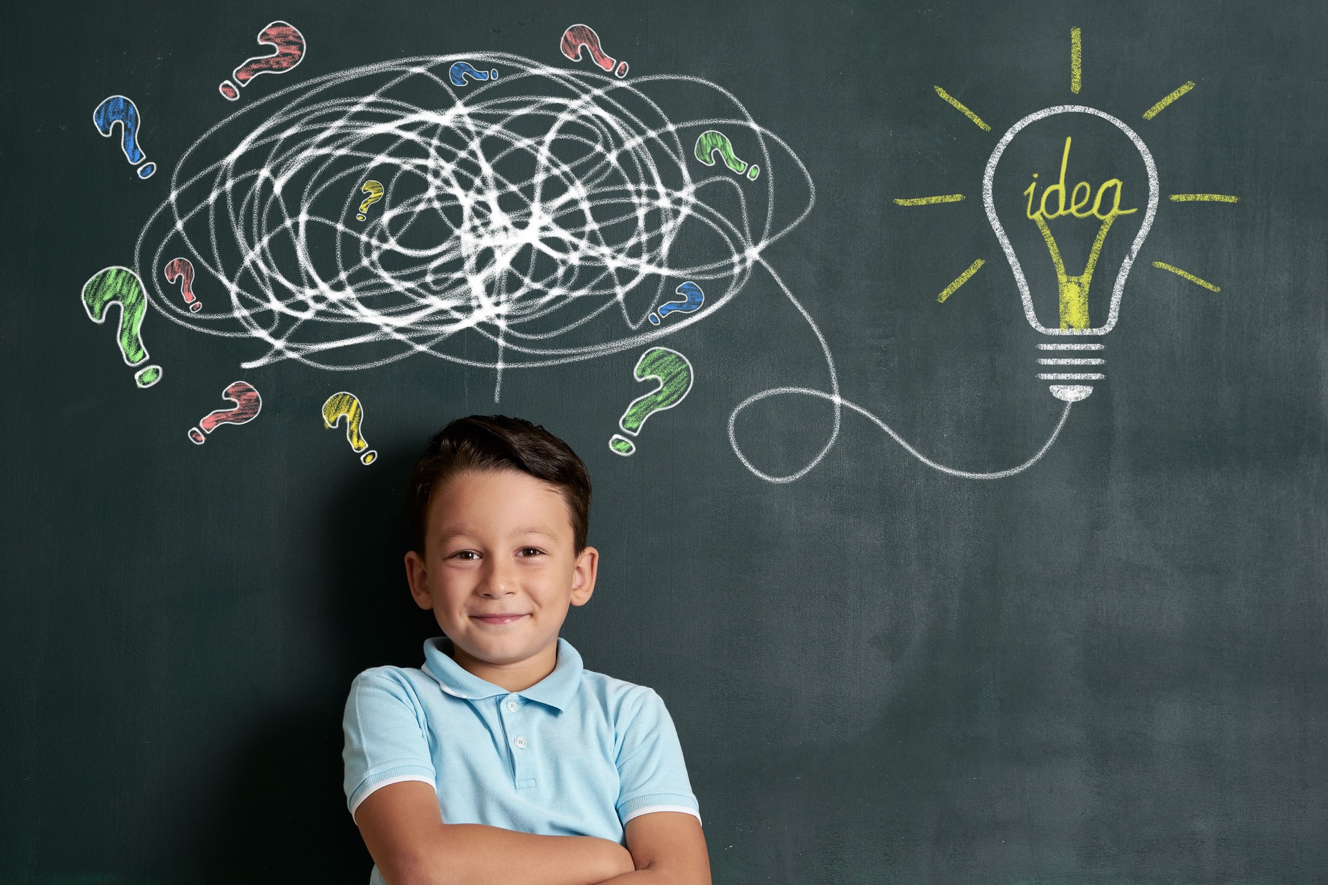 6-7 years child is finding solution on front of blackboard